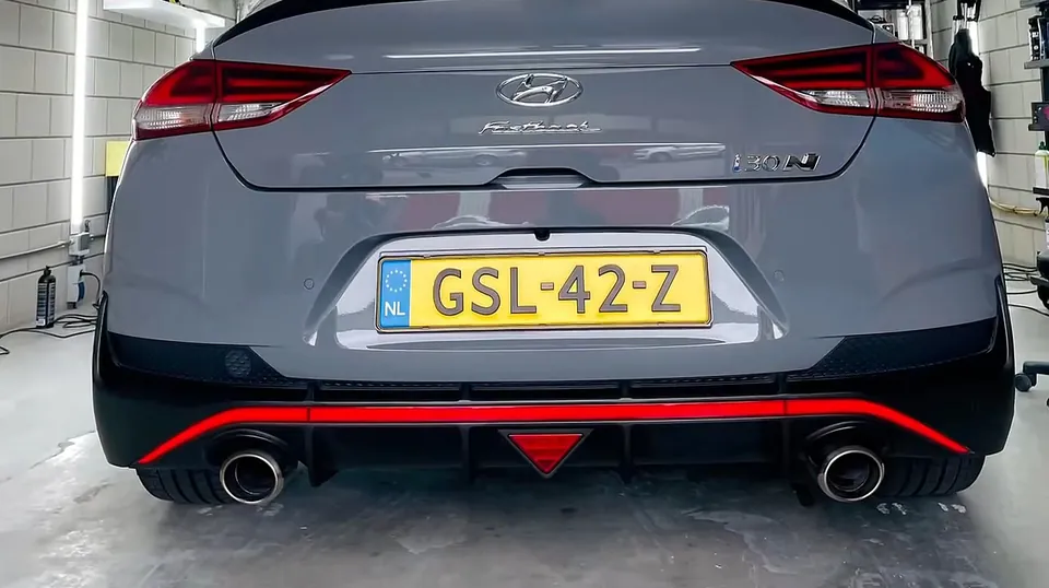 Grijze Hyundai i30 Fastback met de hexagonale lampen gespiegeld in de achterklep